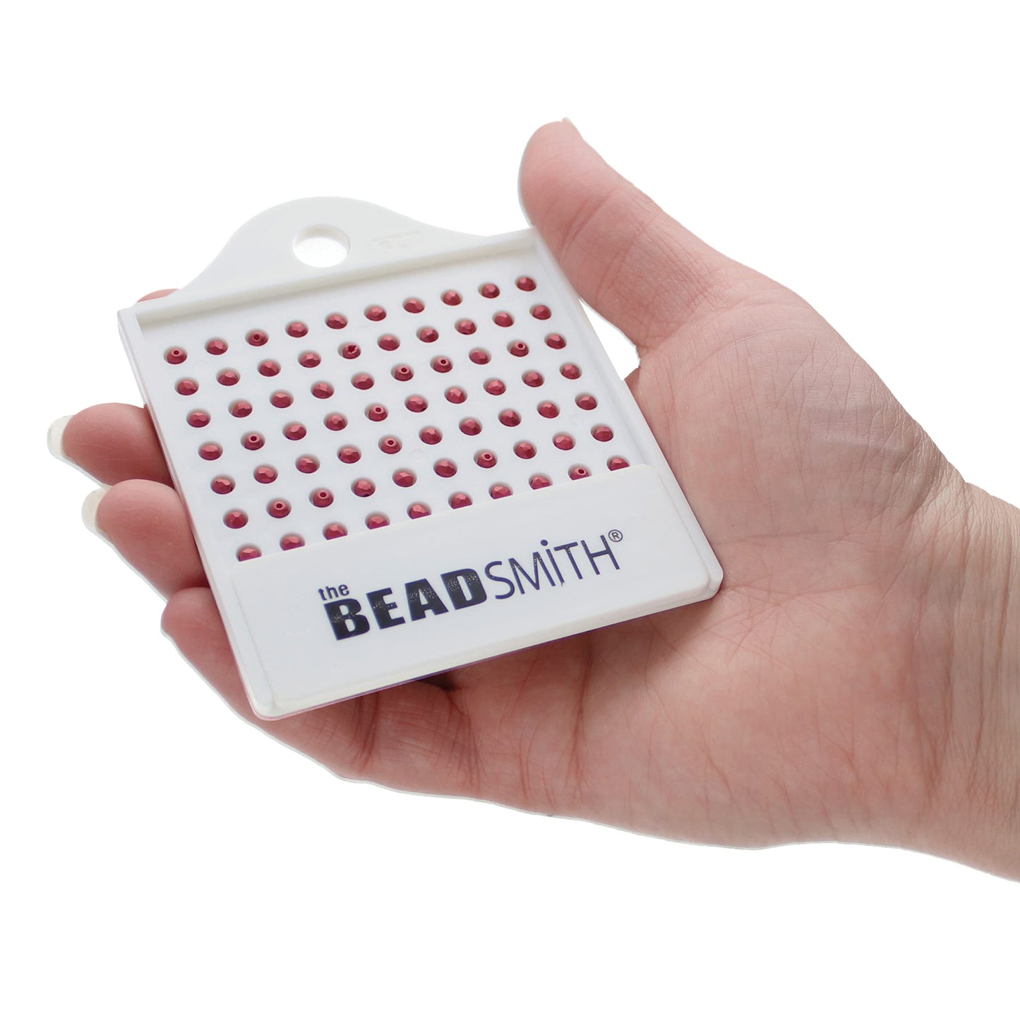 Hand holding a Beadsmith bead sorting tray filled with red beads.