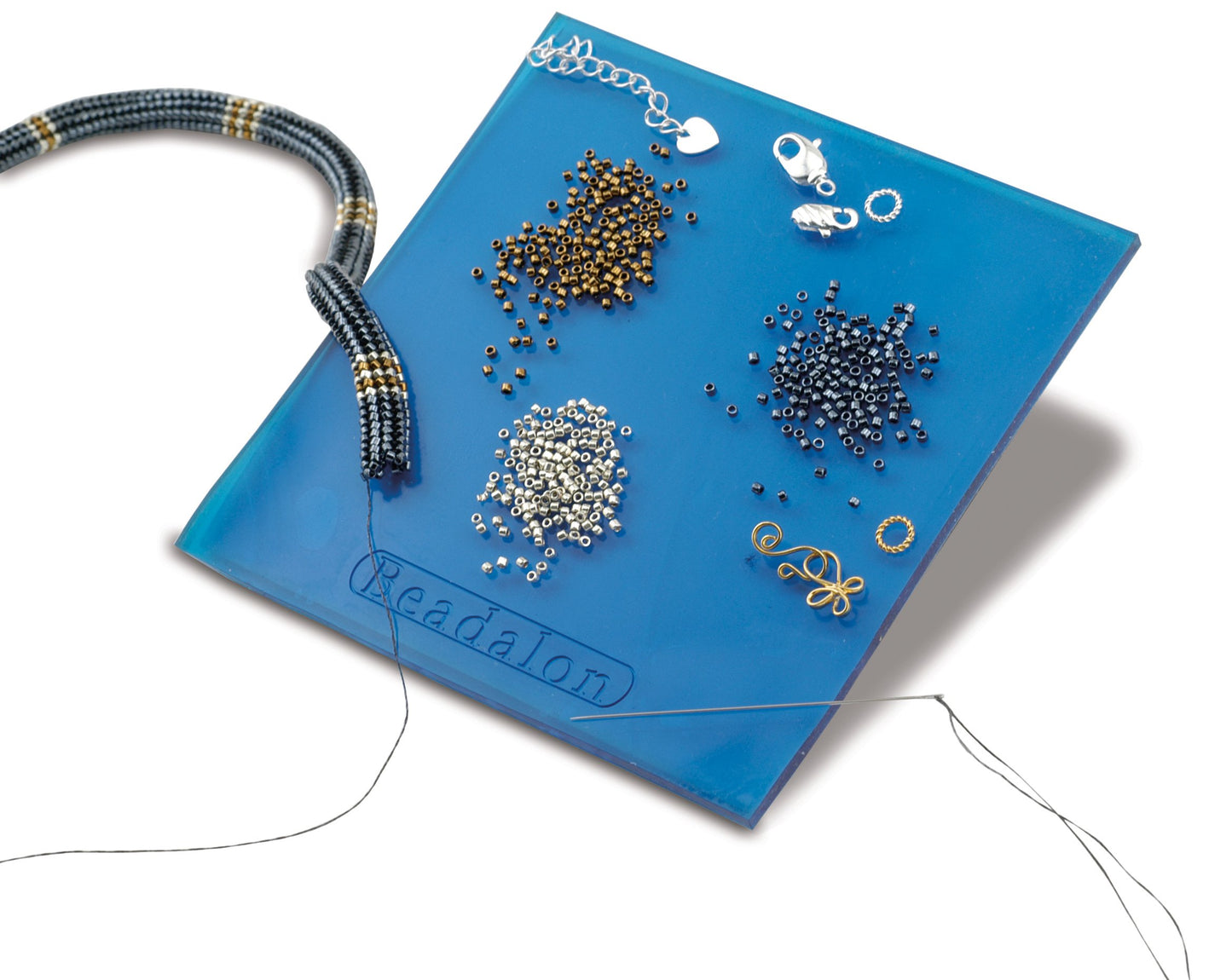 Beadalon bead board with various seed beads, findings, needle and thread. Jewelry making supplies.