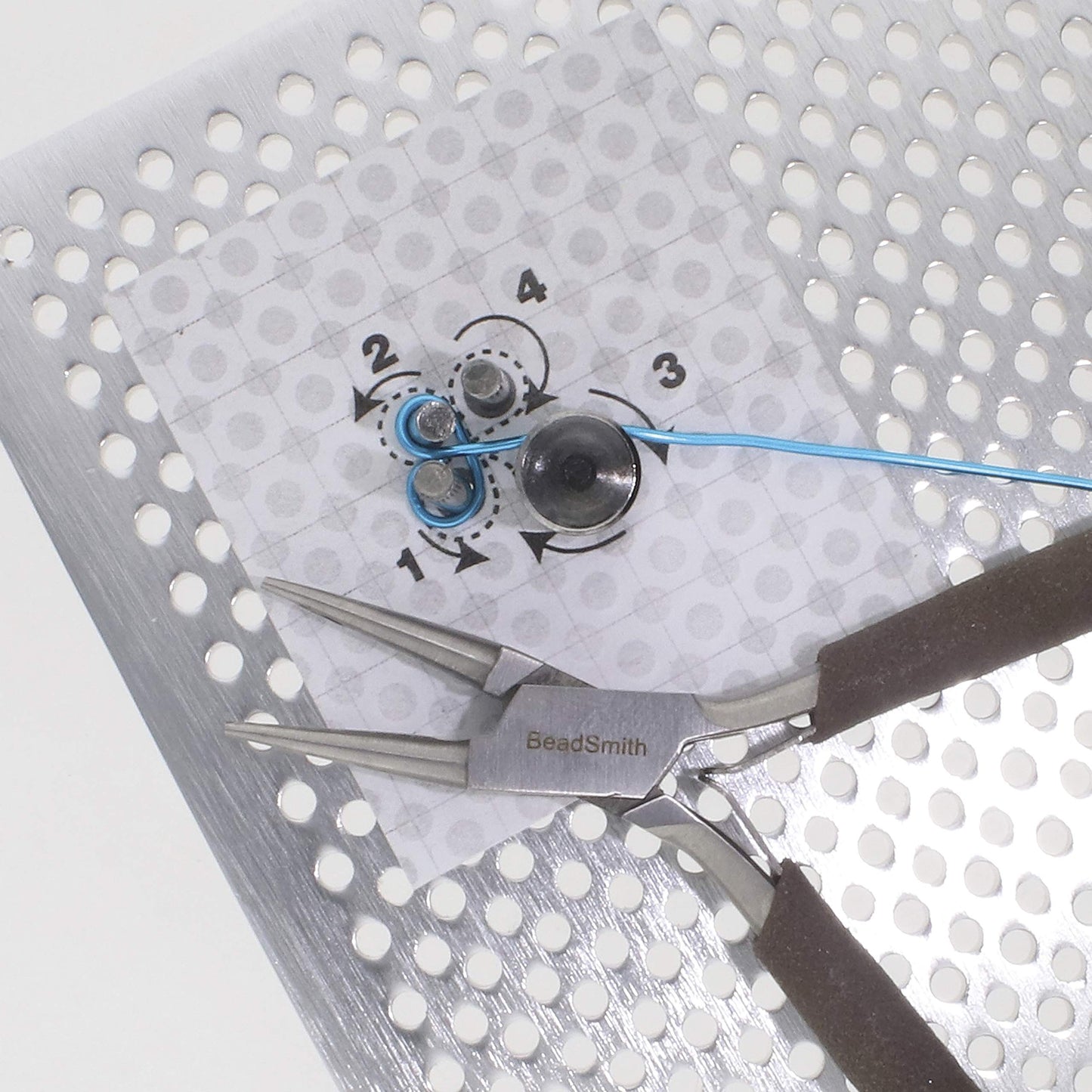 BeadSmith pliers and blue wire on a jig, used for creating jewelry components.