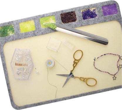 BeadSmith bead board with beads, scissors, tool, thread, and clasps for jewelry making.